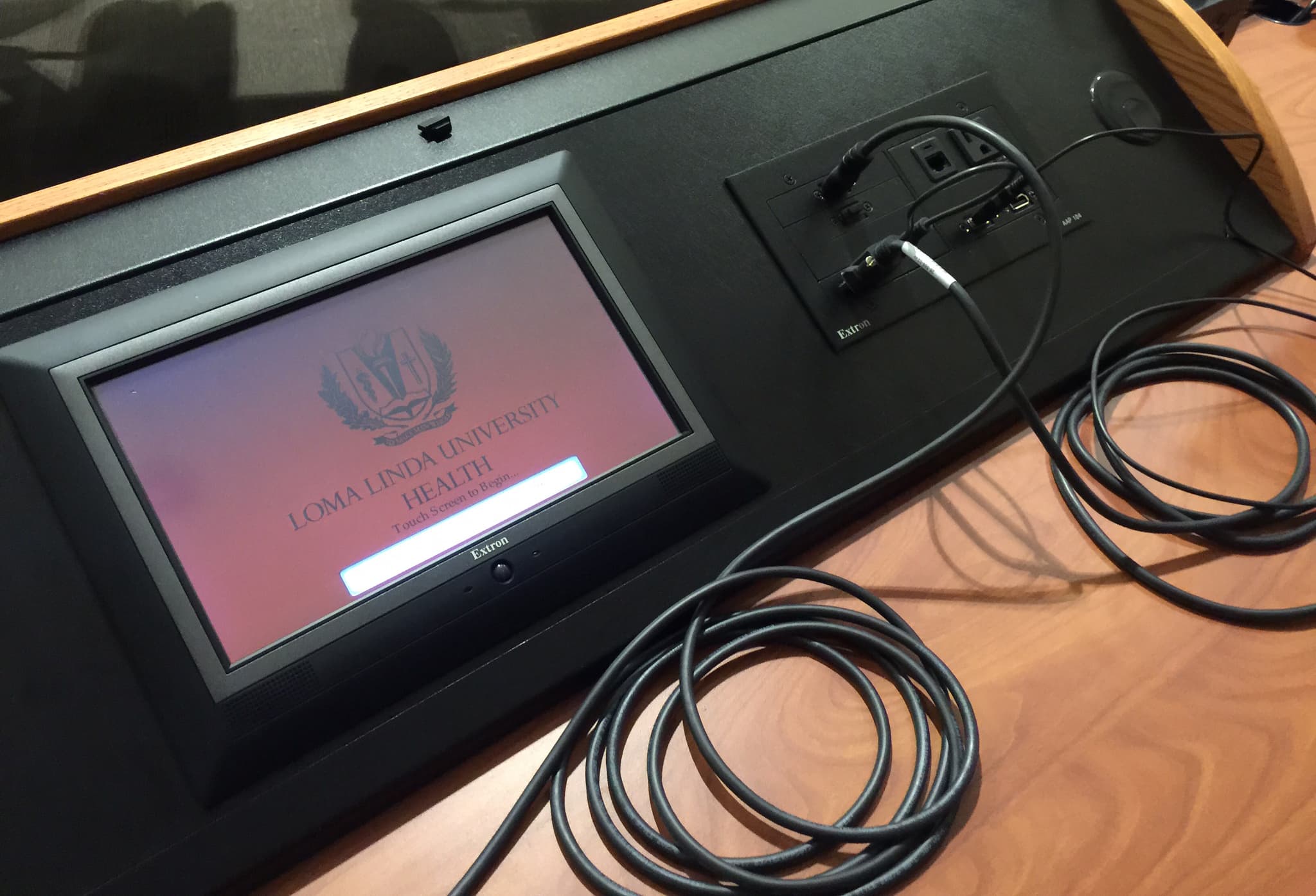 Loma Linda University Health touchscreen control panel mounted in a lectern with visible cable management