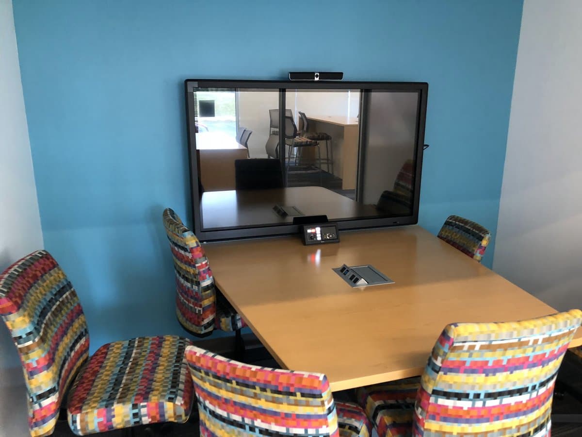 Huddle room with wall-mounted display and conferencing camera installed by RTZ